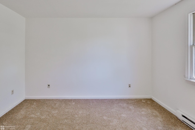carpeted empty room featuring baseboards and baseboard heating