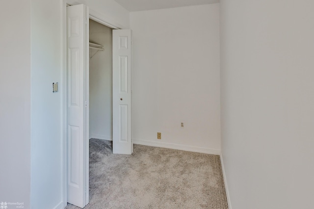 unfurnished bedroom with a closet, baseboards, and carpet flooring