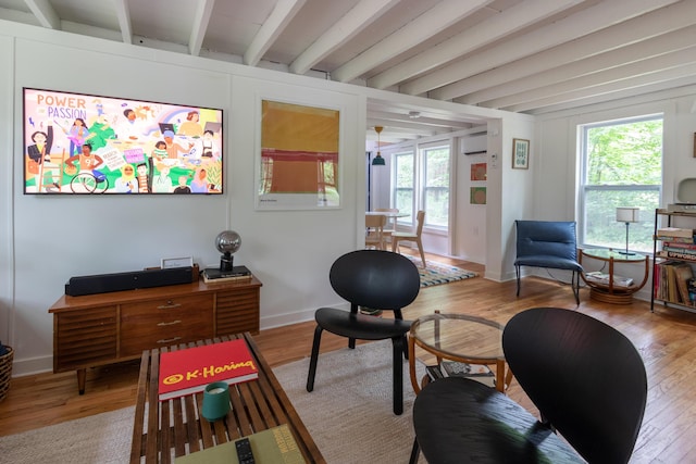 235 3rd St, Pocono Pines, PA 18350 - living area featuring beam ceiling, wood finished floors, healthy amount of natural light, an AC wall unit, and baseboards