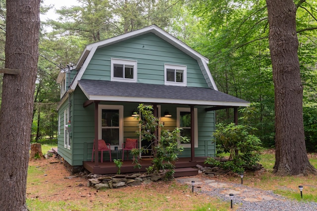 235 3rd St, Pocono Pines, PA 18350 - colonial inspired home with a gambrel roof, covered porch, and a shingled roof
