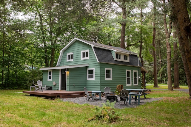 235 3rd St, Pocono Pines, PA 18350 - back of property featuring a wooden deck, a gambrel roof, a yard, and a shingled roof