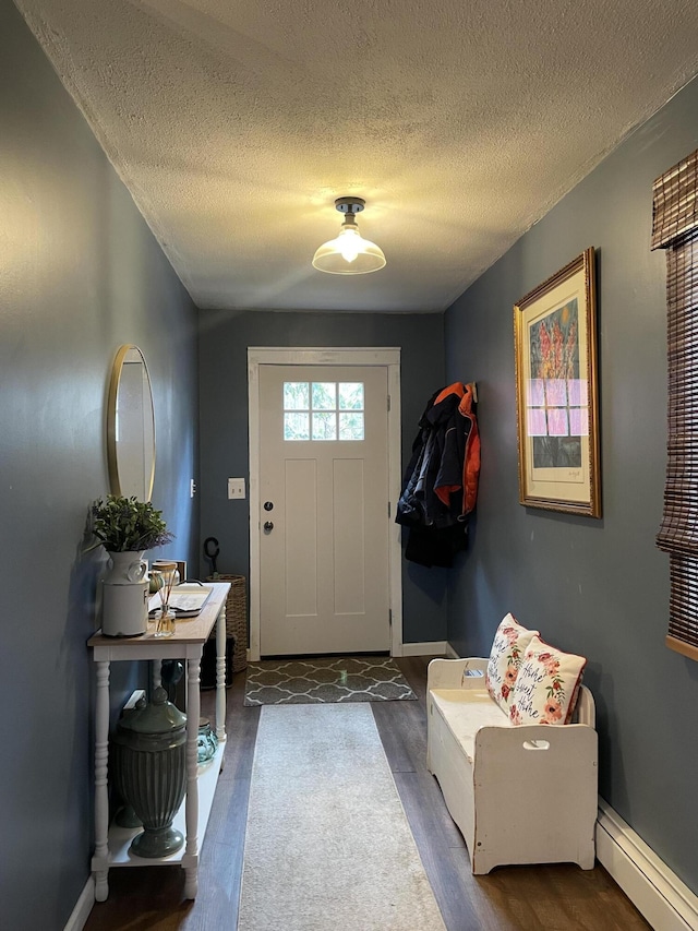 entryway featuring dark wood-type flooring, baseboards, a textured ceiling, and baseboard heating