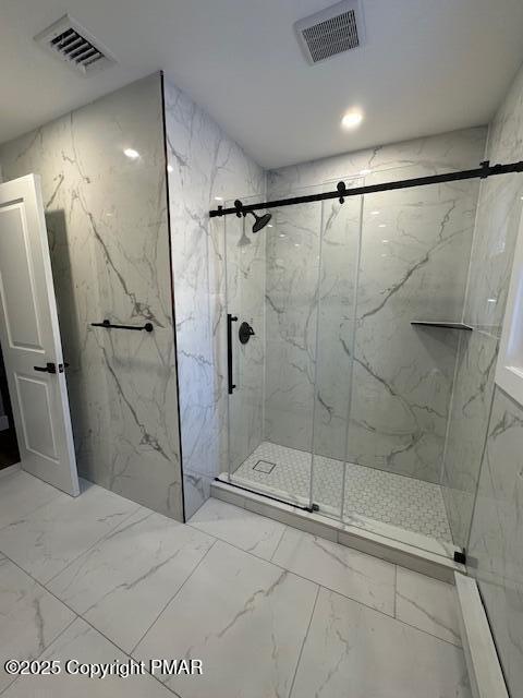 full bath with marble finish floor, a marble finish shower, and visible vents