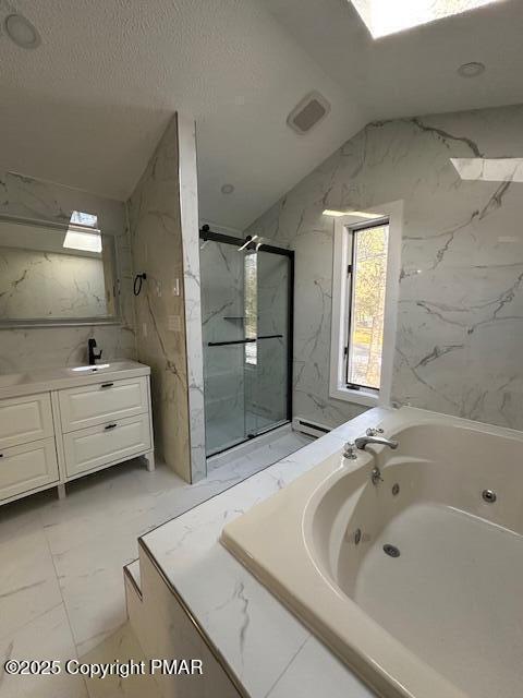 bathroom featuring a textured ceiling, vanity, marble finish floor, a marble finish shower, and a whirlpool tub