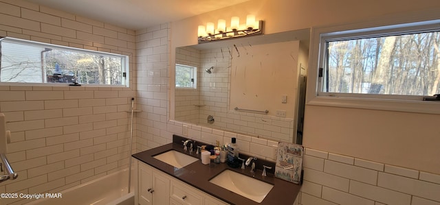 full bath featuring tile walls, shower / bath combination, and a sink