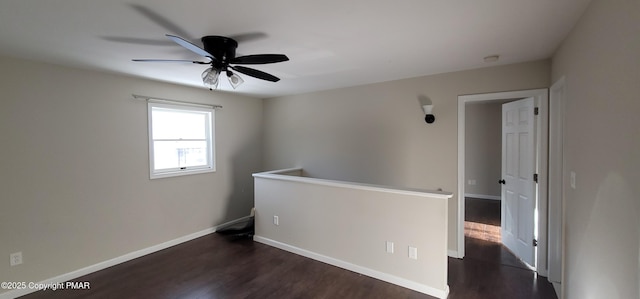 spare room with dark wood-type flooring and baseboards