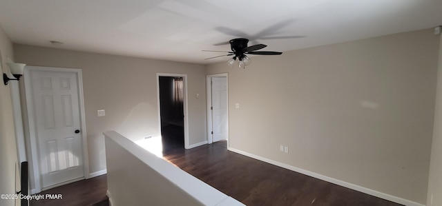 hall featuring an upstairs landing, dark wood-style floors, and baseboards