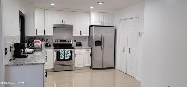 kitchen featuring under cabinet range hood, backsplash, appliances with stainless steel finishes, and white cabinetry