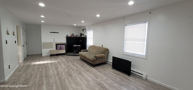 sitting room featuring a baseboard heating unit, recessed lighting, baseboards, and light wood finished floors