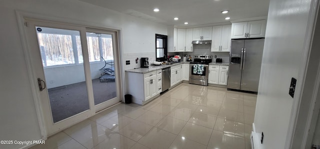 kitchen with under cabinet range hood, white cabinetry, recessed lighting, appliances with stainless steel finishes, and decorative backsplash