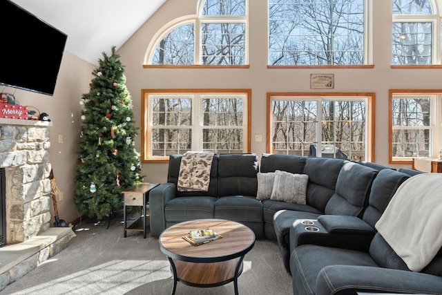 living room with a fireplace, high vaulted ceiling, and carpet