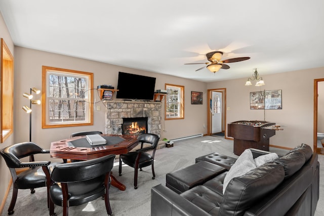 living room featuring light carpet, a stone fireplace, baseboards, baseboard heating, and ceiling fan