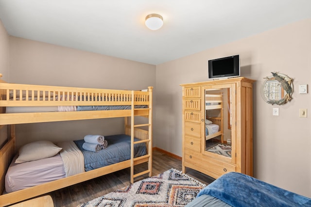 bedroom with wood finished floors and baseboards