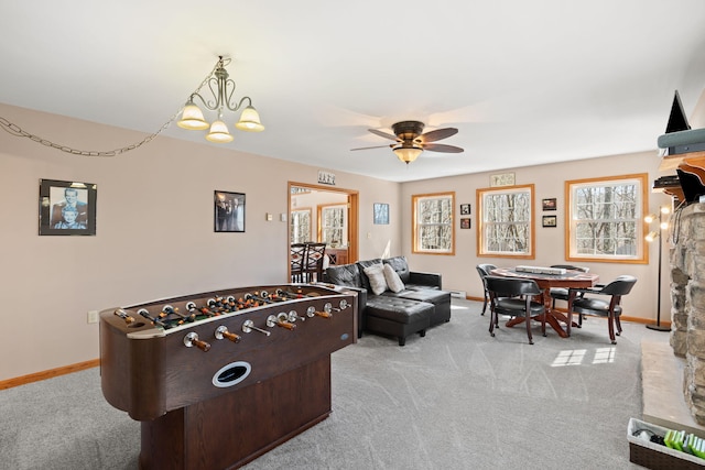 rec room featuring ceiling fan with notable chandelier, carpet, and baseboards