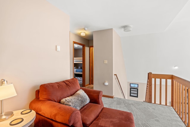 living area with carpet flooring and an upstairs landing