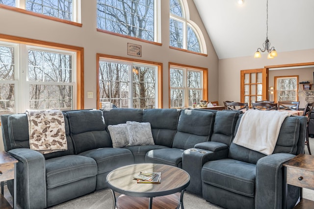 living area with high vaulted ceiling and a chandelier