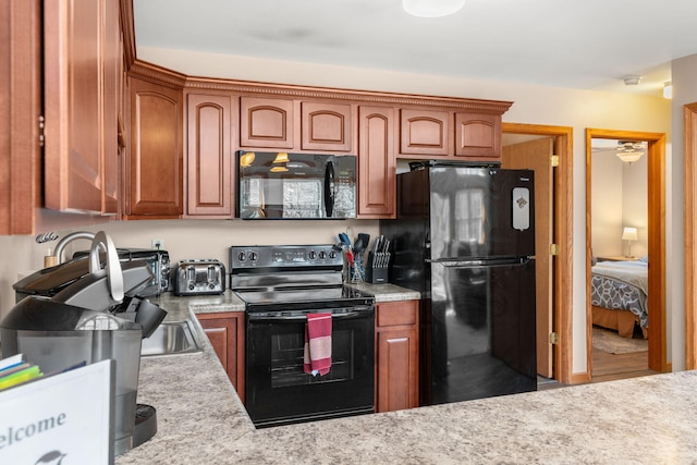 kitchen featuring brown cabinets, black appliances, a toaster, and light countertops