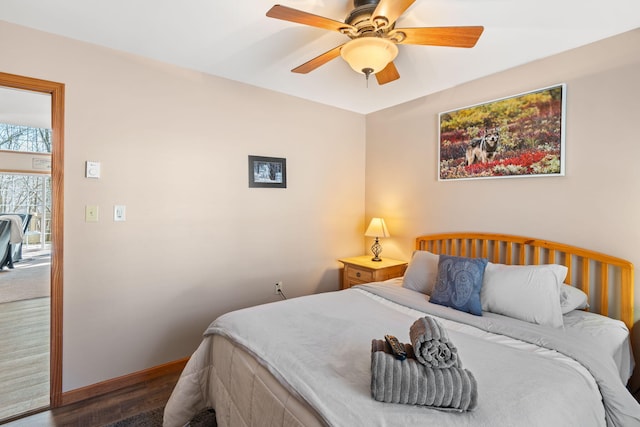 bedroom featuring baseboards, wood finished floors, and a ceiling fan