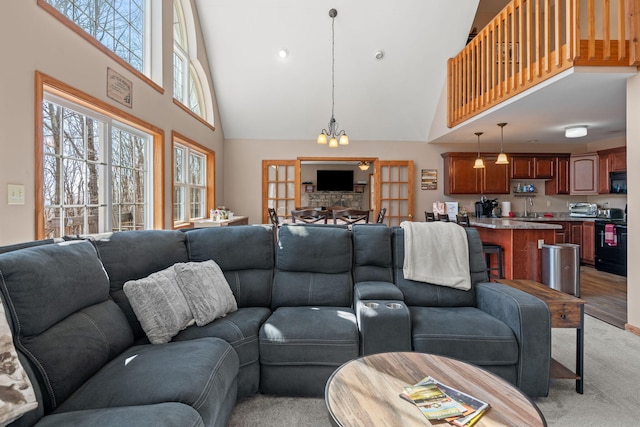 living room featuring a toaster, a towering ceiling, and a chandelier