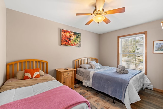 bedroom featuring a ceiling fan, wood finished floors, baseboards, and baseboard heating