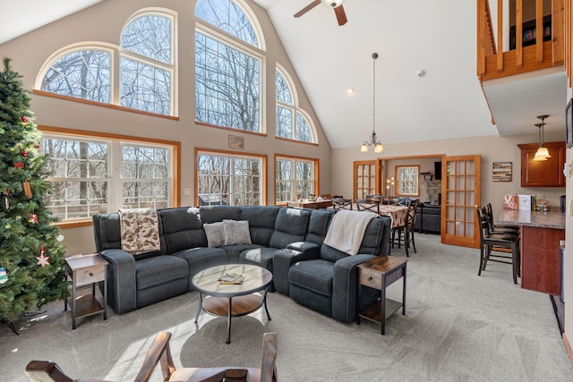 living area with light colored carpet and ceiling fan with notable chandelier