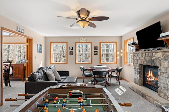 playroom with a healthy amount of sunlight, a fireplace, ceiling fan, and carpet floors