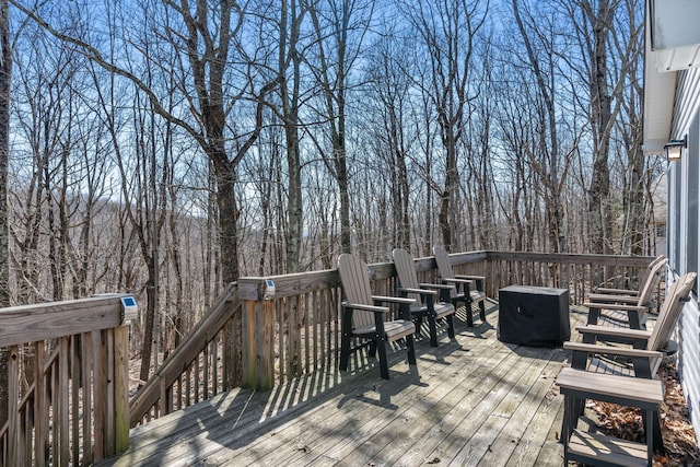 wooden terrace featuring a wooded view