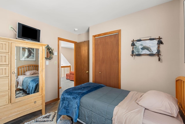 bedroom featuring a closet, baseboards, and wood finished floors