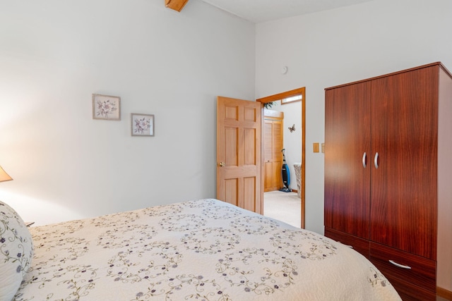 bedroom with a closet, carpet floors, and high vaulted ceiling
