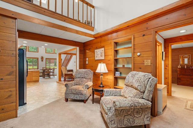 sitting room with recessed lighting, wooden walls, and light carpet