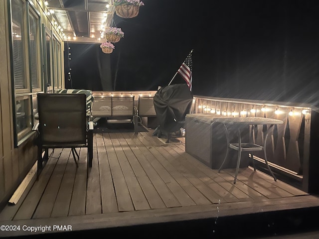 deck at night featuring grilling area