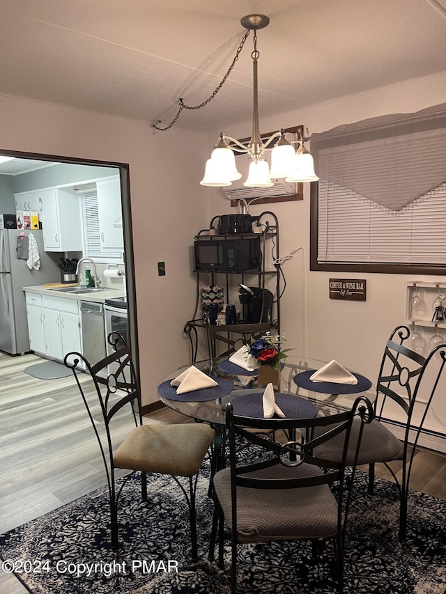 dining space featuring light wood-style floors and an inviting chandelier