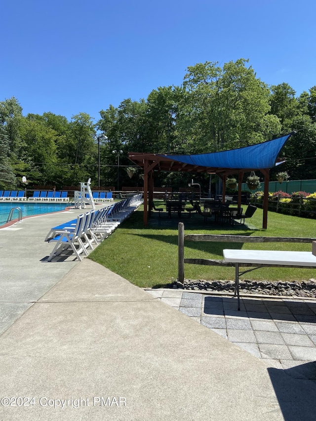 surrounding community featuring a lawn, a patio area, a swimming pool, and fence