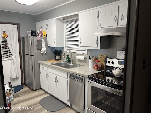 kitchen with white cabinets, appliances with stainless steel finishes, light countertops, under cabinet range hood, and a sink