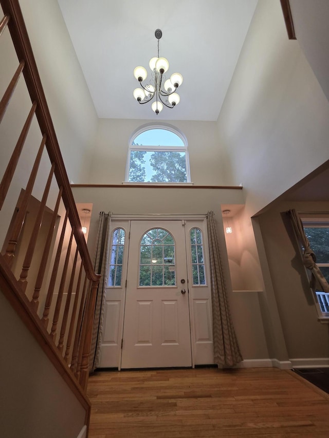 210 Grouse Run, Cresco, PA 18326 - foyer with a towering ceiling, a chandelier, stairs, and wood finished floors