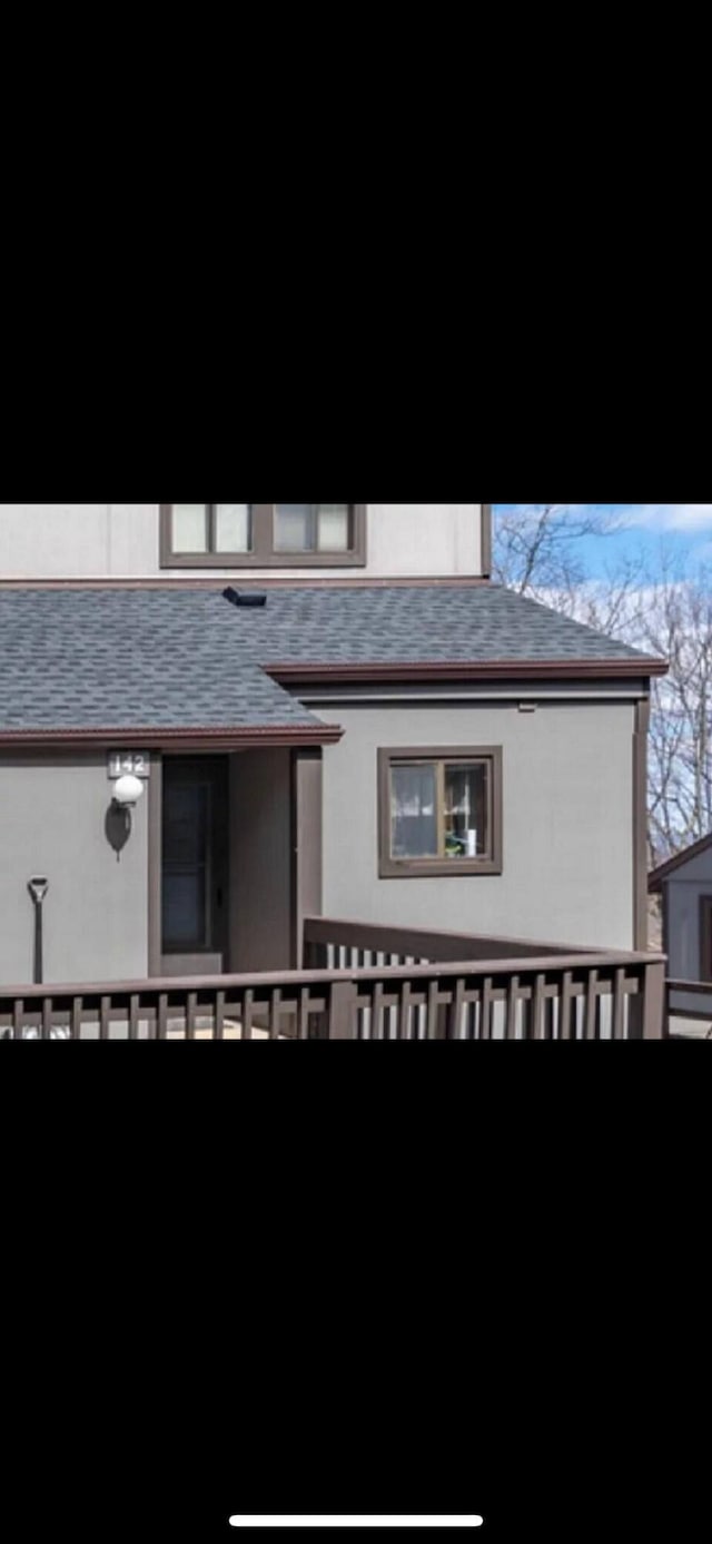 view of front of home featuring stucco siding and a shingled roof