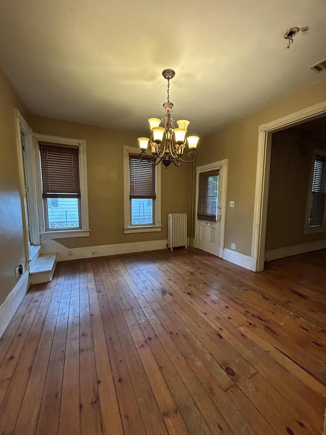 58-60 Broad St, Stroudsburg, PA 18360 - unfurnished dining area featuring radiator, a chandelier, wood-type flooring, and plenty of natural light