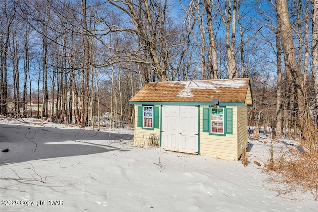 snow covered structure with a storage unit and an outdoor structure