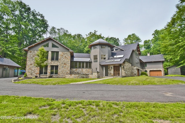 386 Camelback Rd, Tannersville, PA 18372 - view of front of home with a chimney, driveway, stone siding, an attached garage, and a front yard