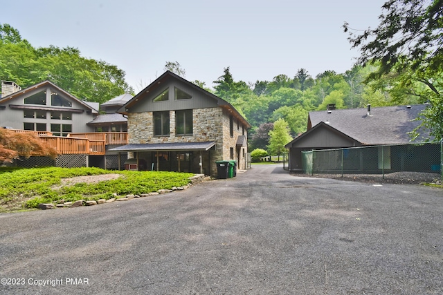 386 Camelback Rd, Tannersville, PA 18372 - exterior space featuring a wooden deck, aphalt driveway, fence, and stone siding