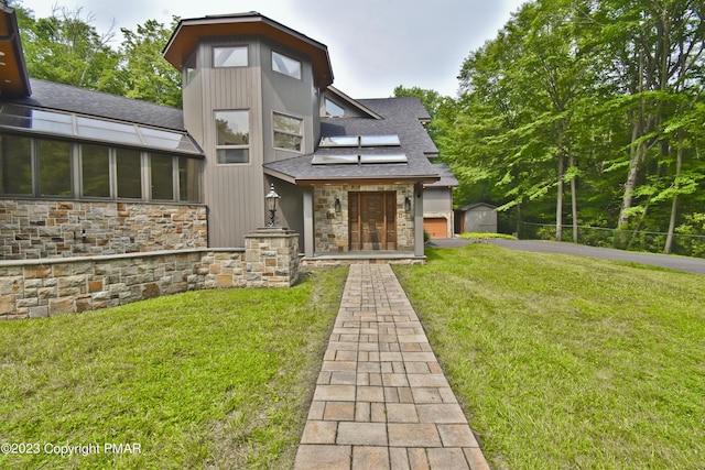 386 Camelback Rd, Tannersville, PA 18372 - rear view of property with a shingled roof, stone siding, and a lawn