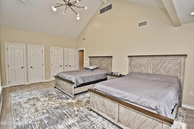 386 Camelback Rd, Tannersville, PA 18372 - bedroom with an inviting chandelier, two closets, visible vents, high vaulted ceiling, and wood finished floors