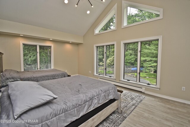 386 Camelback Rd, Tannersville, PA 18372 - bedroom with baseboards, baseboard heating, recessed lighting, wood finished floors, and high vaulted ceiling