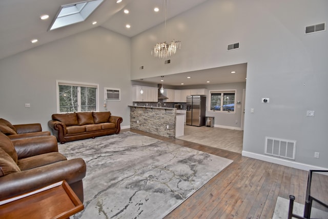 386 Camelback Rd, Tannersville, PA 18372 - living room featuring high vaulted ceiling, light wood finished floors, a notable chandelier, and visible vents