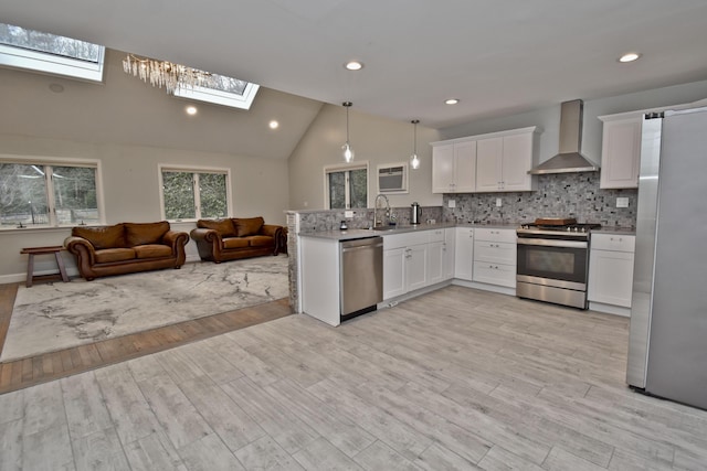 386 Camelback Rd, Tannersville, PA 18372 - kitchen featuring wall chimney exhaust hood, open floor plan, a peninsula, white cabinetry, and stainless steel appliances
