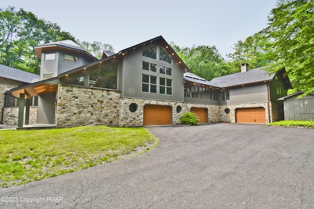386 Camelback Rd, Tannersville, PA 18372 - view of front of house with a front yard, driveway, stone siding, and a chimney