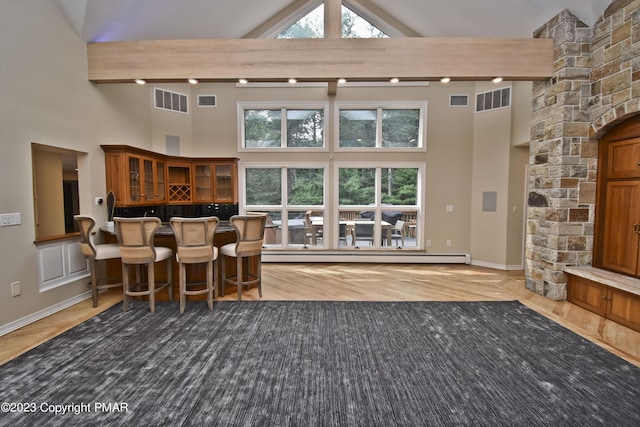 386 Camelback Rd, Tannersville, PA 18372 - living room with high vaulted ceiling, visible vents, a baseboard radiator, and bar
