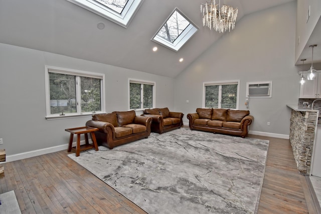 386 Camelback Rd, Tannersville, PA 18372 - living room with an AC wall unit, a wealth of natural light, a skylight, high vaulted ceiling, and hardwood / wood-style floors