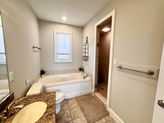 bathroom featuring a garden tub, a stall shower, vanity, tile patterned floors, and toilet