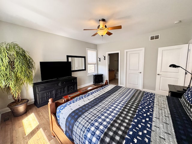 bedroom with baseboards, a ceiling fan, wood finished floors, and visible vents